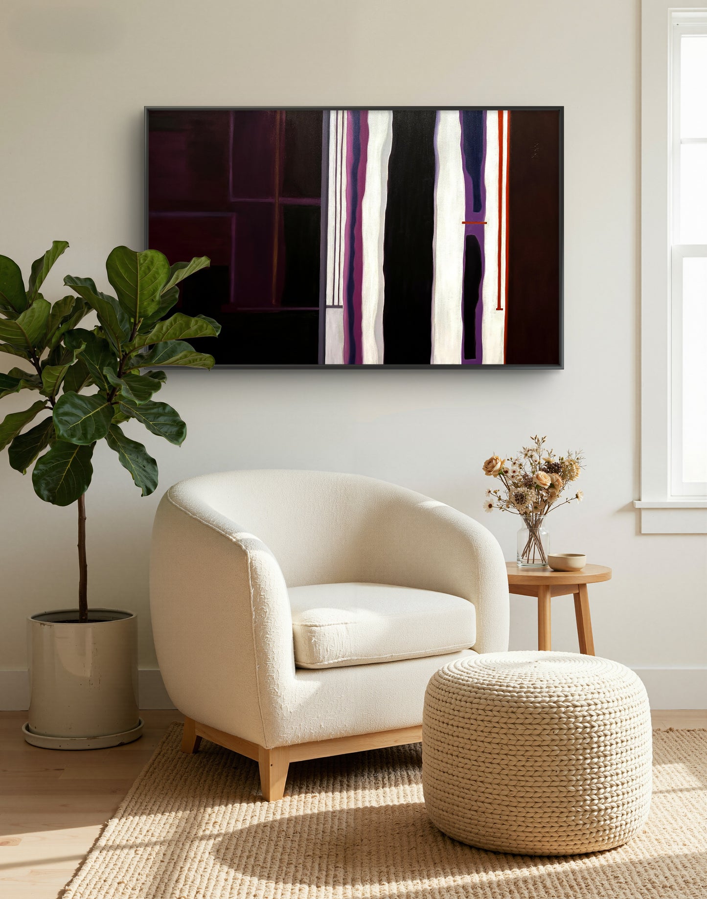 Modern living room with a white armchair, ottoman, and abstract painting on the wall.