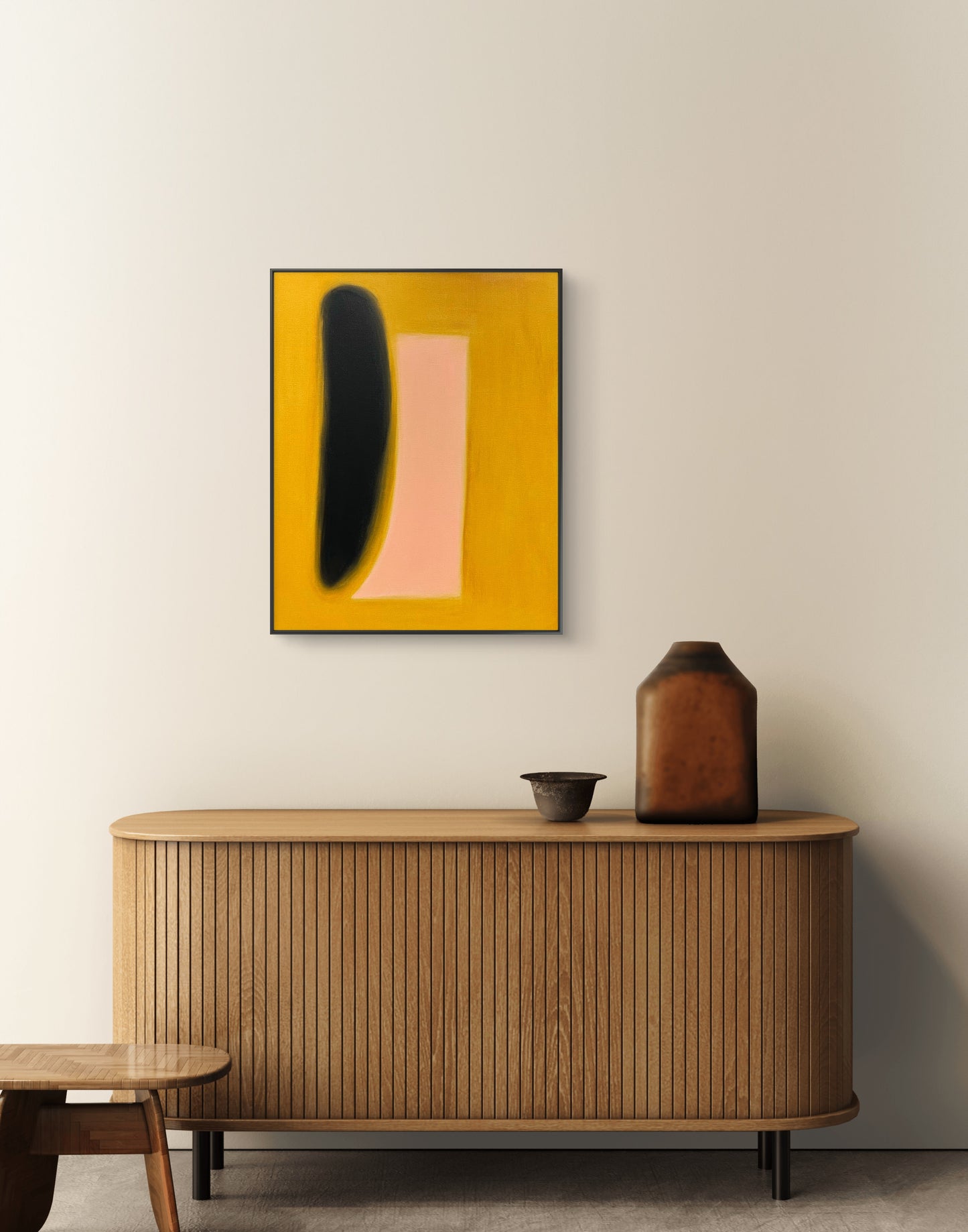Abstract art piece on a wall above a wooden cabinet with decorative items.