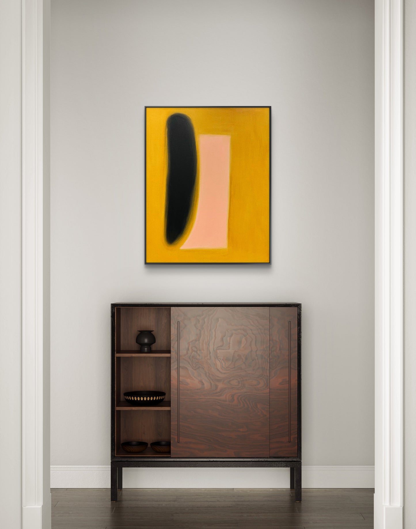 Abstract art piece on a wall above a wooden cabinet