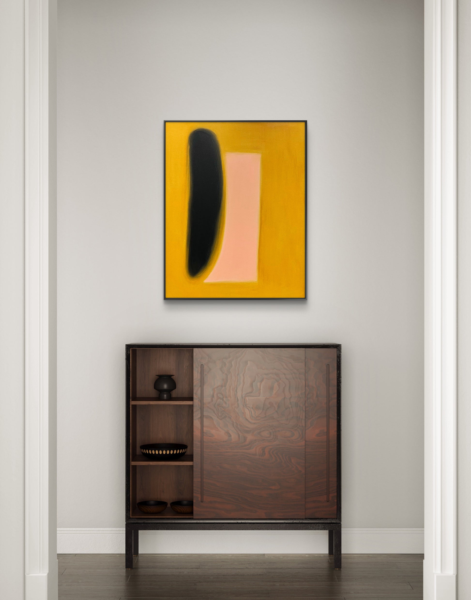 Abstract art piece on a wall above a wooden cabinet